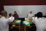 Petugas Kantor Imigrasi Kelas II Non TPI Blitar merekam data Jamaah Calon Haji (JCH) tahun 2021 di Kantor Kementrian Agama Blitar, Jawa Timur, Rabu (7/4/2021). Perekaman data untuk permohonan paspor tersebut tetap dilaksanakan oleh Kemenag yang bekerjasama dengan Imigrasi, meski pemerintah Indonesia belum mendapat informasi terkait kepastian penyelenggaraan haji tahun 2021. Antara Jatim/Irfan Anshori/zk