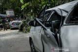 Petugas Dpkp3 Kota Bandung mengevakuasi pohon tumbang yang menimpa mobil di Bandung, Jawa Barat, Kamis (8/4/2021). Sedikitnya lima mobil mengalami rusak akibat tertimpa pohon yang diduga tumbang akibat cuaca angin kencang yang terjadi di Kota Bandung. ANTARA JABAR/Novrian Arbi/agr
