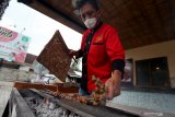 Pedagang membakar sate untuk disiapkan dalam lomba makan sate kambing di salahsatu rumah makan di Kota Blitar, Jawa Timur, Kamis (8/4/2021). Selain bertujuan untuk mengkampanyekan makanan sate sebagai makanan khas indonesia, lomba makan sate kambing dengan tajuk #SateChallange tersebut juga bertujuan untuk mengajak masyarakat mengkonsumsi sate kambing sebagai salah satu upaya untuk meningkatkan imun guna melawan penularan COVID-19. Antara Jatim/Irfan Anshori/zk