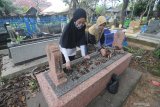  Warga membersihkan makam di Komplek Pemakaman Astah Barat, Pamekasan, Jawa Timur, Jumat (9/4/2021). Bersih-bersih makam keluarga atau tradisi 'Ngosar' yang dilakukan sepekan sebelum bulan puasa dan sebelum Idul Fitri, merupakan tradisi penghormatan sekaligus mendoakan keluarganya yang sudah meninggal.  Antara Jatim/Saiful Bahri/zk