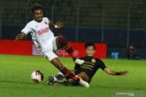 Pesepak bola PSM Makassar, Yakob Sayuri (kiri) berusaha melewati tubuh pesepak bola PSIS Semarang, Finky Pasamba (kanan) yang terjatuh dalam pertandingan Babak Perempat Final Piala Menpora di Stadion Kanjuruhan, Malang, Jawa Timur, Jumat (9/4/2021). PSM Makassar berhak melaju ke babak semifinal setelah mengalahkan PSIS Semarang melalui adu pinalti dengan skor akhir 4-2.  Antara Jatim/Ari Bowo Sucipto/zk