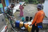 Petugas Badan Penanggulangan Bencana Daerah (BPBD) dan Babinsa mengirim bantuan air bersih di Desa Sopet, Jangkar, Situbondo, Jawa Timur, Jumat (9/4/2021). Bantuan air bersih untuk 200 kepala keluarga di dusun tersebut diperlukan pasca pipa saluran air putus terkena longsor dua bulan terakhir. Antara Jatim/Seno/zk