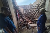 Warga menatap bangunan rumahnya yang runtuh terdampak gempa di Tulungagung, Jawa Timur, Sabtu (10/4/2021). Sebanyak 49 rumah, dua mushala dan dua masjid  yang tersebar di 28 desa 12 kecamatan dilaporkan rusak akibat  gempa berkekuatan 6,7 SR yang melanda pesisir selatan Jawa pada Sabtu siang, sekitar pukul 14.00 WIB. Antara Jatim/Destyan Sujarwoko/zk.