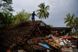 Warga berusaha mengumpulkan barang berharga miliknya yang berada diantara reruntuhan rumahnya yang rubuh akibat gempa di Desa Kali Uling, Lumajang, Jawa Timur, Minggu (11/4/2021). Sekitar ratusan rumah warga di wilayah itu rusak akibat gempa M 6,1 yang terjadi di Kabupaten Malang pada Sabtu (10/4). Antara Jatim/Zabur Karuru