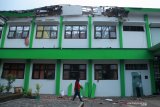 Seorang warga melintas di depan bangunan sekolah yang rusak akibat gempa di SMK Negeri 1 Turen, Malang, Jawa Timur, Sabtu (10/4/2021). Gempa dengan kekuatan 6,7 SR yang mengguncang kawasan Malang dan sekitarnya membuat sejumlah bangunan rusak. Antara Jatim/Bayu/abs/zk.