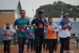 Pejabat Kepala Organisasi Perangkat Daerah (OPD) Pemkot Madiun mengikuti test kebugaran di Stadion Wilis Kota Madiun, Jawa Timur, Sabtu (10/4/2021). Tes kebugaran yang diikuti Wali Kota Maidi dan seluruh pejabat kepala OPD meliputi cek kesehatan, senam dan berlari atau berjalan cepat sesuai kemampuan sejauh 1.600 meter, sebagai salah satu upaya meningkatkan kinerja jantung, paru-paru dan otot guna mengetahui tingkat kebugaran serta deteksi dini penyakit tidak menular. Antara Jatim/Siswowidodo/zk.