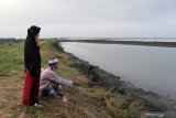 Warga korban lumpur Lapindo menaburkan bunga untuk keluarga mereka yang telah wafat saat ziarah jelang ramadhan di tanggul Porong, Sidoarjo, Jawa Timur, Minggu (11/4/2021). Mereka berdoa dari pinggir tanggul karena makam keluarganya telah tenggelam oleh lumpur. Antara Jatim/Umarul Faruq/zk.