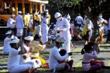 Pemuka agama Hindu memercikkan air suci saat persembahyangan Hari Raya Galungan di Pura Jagatnatha, Denpasar, Bali, Rabu (14/4/2021). Perayaan Hari Raya Galungan yang merupakan hari kemenangan kebenaran (Dharma) atas kejahatan (Adharma) itu diikuti umat Hindu di Bali dengan menerapkan protokol kesehatan untuk mencegah penyebaran pandemi COVID-19. ANTARA FOTO/Fikri Yusuf/nym.