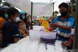 Penjual musiman minuman takjil melayani pembeli di kawasan Alun-alun Kota Madiun, Jawa Timur, Selasa (13/4/2021). Puluhan penjual musiman memanfaatkan momentum puasa Ramadhan dengan menjual makanan dan minuman untuk takjil, antara lain es buah, es kopyor, kolak dan berbagai jenis makanan dengan harga antara Rp5.000 hingga Rp10.000 per kemasan. Antara Jatim/Siswowidodo/zk.