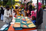 Penjual musiman makanan takjil melayani pembeli di kawasan Alun-alun Kota Madiun, Jawa Timur, Selasa (13/4/2021). Puluhan penjual musiman memanfaatkan momentum puasa Ramadhan dengan menjual makanan dan minuman untuk takjil, antara lain es buah, es kopyor, kolak dan berbagai jenis makanan dengan harga antara Rp5.000 hingga Rp10.000 per kemasan. Antara Jatim/Siswowidodo/zk.