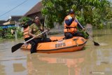 Petugas Badan Penanggulangan Bencana Daerah (BPBD) memantau kondisi banjir di Desa Jerukgulung, Balerejo, Kabupaten Madiun, Jawa Timur, Kamis (15/4/2021). Sejumlah desa di empat kecamatan di Kabupaten Madiun terendam banjir luapan Sungai Jeroan akibat hujan deras Rabu (14/4) sore hingga malam. Antara Jatim/Siswowidodo/zk