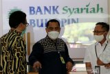 Direktur Utama PT Bank Syariah Bukopin (BSB) Dery Januar (dua kanan) berbincang dengan nasabah yang menabung di BSB KB Banda Aceh, Aceh, Jumat (16/4/2021). PT Bank KB Bukopin membuka layanan syariah bank umum di provinsi Aceh sebagai implementasi dan menyukseskan peraturan daerah (qanun) Aceh nomor 11/2018 tentang Layanan Keuanagn Syariah (LKS). Antara Aceh/Irwansyah Putra.