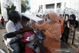 Pengurus dan anggota Dharma Wanita Persatuan (DWP) dan Aparatur Sipil Negara (ASN) Sekretariat Dewan Perwakilan Rakyat Kota (DPRK) Banda Aceh membagikan paket dan takjil berbuka puasa kepada pengguna jalan di Banda Aceh, Aceh, Jumat (16/4/2021). Pembagian paket dan takjil berbuka puasa tersebut dilaksanakan sebagai wujud kepedulian, berbagi dan bersedekah kepada umat muslim yang sedang menjalankan ibadah di bulan suci Ramadhan. Antara Aceh/Irwansyah Putra.