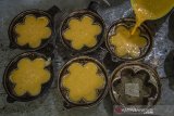 Pekerja membuat kue bingka di rumah produksi Bingka H Thamrin Salon di Banjarmasin, Kalimantan Selatan, Sabtu (17/4/2021). Rumah produksi kue khas Banjar tersebut dalam sehari mampu memproduksi 1.100 kue bingka dengan harga Rp45 ribu per buah untuk melayani permintaan yang meningkat selama bulan Ramadhan. Foto Antaranewa Kalsel/Bayu Pratama S.