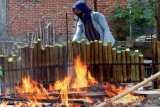 Warga membakar lemang di Gampong Blowe, Banda Aceh, Aceh, Sabtu (17/4/2021). Lemang yang dikenal di Indonesia, Malaysia, Cina, Korea dan Singapura merupakan makanan yang terbuat dari beras ketan yang dimasak dengan cara dibakar dalam seruas bambu hingga menjadi takjil favorit dan diminati untuk menu berbuka puasa pada bulan Ramadhan. Antara Aceh/Irwansyah Putra