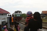 Sejumlah warga melihat Kereta Api (KA) sambil menunggu saat berbuka puasa atau ngabuburit di sekitar jalur KA dekat kawasan Stasiun KA Madiun, Jawa Timur, Minggu (18/4/2021). Sebagian warga bersama keluarganya memanfaatkan waktu untuk ngabuburit di lokasi itu sambil melihat perjalanan sejumlah KA. Antara Jatim/Siswowidodo/zk