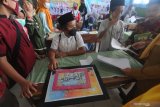 Siswa mengumpulkan tugas  penulisan surah pendek juz 30 Al Quran saat Pondok Ramadhan di SDN Lawangan Daya 2, Pamekasan, Jawa Timur, Senin (19/4/2021). Selain diharuskan mampu menghafal juz 30 atau juz Amma, siswa tingkat SD dan SMP di Kabupaten itu, juga diharapkan mampu menulis surah pendek juz 30 Al Quran dengan baik dan benar. Antara Jatim/Saiful Bahri/zk