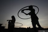 Dua anak bermain hula hoop saat ngabuburit 