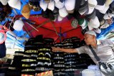 Pedagang Kaki Lima menata peci motif Aceh yang dijajakan di kawasan Masjid Raya Baiturrahman, Banda Aceh, Aceh, Rabu (21/4/2021). Peci yang dibordir berbagai motif khas Aceh mengalami penurunan permintaan hingga 50 persen dibanding Ramadhan tahun lalu yang dijual Rp25.000 hingga Rp75.000 perunit tergantung kualitas bordiran motif dan bahan. Antara Aceh/Irwansyah Putra.