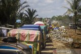 Sejumlah truk mengantre untuk melintas di jalan Gubernur Syarkawi di Kabupaten Banjar, Kalimantan Selatan, Kamis (22/4/2021). Pasca bencana alam banjir, ruas jalan nasional yang menghubungkan Provinsi Kalimantan Selatan dengan Provinsi Kalimantan Tengah itu masih mengalami kerusakan sehingga berpotensi menghambat distribusi barang di saat meningkatnya kebutuhan masyarakat jelang lebaran. Foto Antaranews Kalsel/Bayu Pratama S.