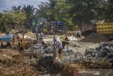 Sejumlah pekerja memperbaiki Jalan Gubernur Syarkawi yang rusak di Kabupaten Banjar, Kalimantan Selatan, Kamis (22/4/2021). Pasca bencana alam banjir, ruas jalan nasional yang menghubungkan Provinsi Kalimantan Selatan dengan Provinsi Kalimantan Tengah itu masih mengalami kerusakan sehingga berpotensi menghambat distribusi barang di saat meningkatnya kebutuhan masyarakat jelang lebaran. Foto Antaranews Kalsel/Bayu Pratama S.