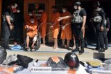 Polisi menghadirkan pelaku kejahatan ganjal ATM lintas provinsi bersama barang bukti saat konferensi pers di Mapolda Bali, Denpasar, Bali, Jumat (23/4/2021). Team Resmob Ditreskrimum Polda Bali berhasil menangkap enam pelaku kejahatan ganjal ATM lintas provinsi dengan mengamankan barang bukti berupa data nasabah bank korban dari transaksi penarikan kartu ATM, dua buah potongan mika plastik dari bekas botol air mineral sebagai alat untuk mengganjal lubang pada mulut mesin ATM, uang sebesar Rp 9.238.000 dan peralatan lainnya. ANTARA FOTO/Nyoman Hendra Wibowo/nym.