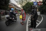 Anggota komunitas Badut Necis membagikan takjil kepada pengendara di Jalan Aruman, CImahi, Jawa Barat, Jumat (23/4/2021). Komunitas Badut Necis membagikan 100 paket takjil dan masker secara gratis kepada warga sebagai bentuk kepedulian terhadap sesama di Bulan Suci Ramadan. ANTARA JABAR/Raisan Al Farisi/agr