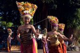 Penari memakai pelindung wajah saat membawakan Tari Rejang Lilit dalam rangkaian Hari Raya Kuningan di Desa Adat Jasri, Karangasem, Bali, Minggu (25/4/2021). Tarian sakral tersebut digelar dengan membatasi jumlah penari yang tampil yakni dari 36 orang menjadi 19 orang untuk mencegah penyebaran COVID-19. ANTARA FOTO/Nyoman Hendra Wibowo/nym.