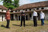 Menteri Koordinator Bidang Pembangunan Manusia dan Kebudayaan (Menko PMK) Muhadjir Effendy (kedua kanan) berbincang dengan Wali Kota Madiun Maidi (kedua kiri) saat meninjau bangunan bekas Rumah Tahanan Militer (RTM) di Kota Madiun, Jawa Timur, Minggu (25/4/2021). Pemkot Madiun merehab bangunan bekas RTM yang dibangun pada masa penjajahan Belanda tersebut sebagai alternatif ruang isolasi para pemudik Lebaran yang positif COVID-19 sekaligus mempersiapkan bangunan tersebut sebagai distinasi wisata sejarah. Antara Jatim/Siswowidodo/zk.