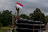  Prajurit Yon Taifib 2 Marinir TNI AL mengibarkan bendera merah putih setengah tiang di posko mereka di Pelabuhan Tanjung Wangi, Banyuwangi, Jawa Timur, Senin (25/4/2021). TNI AL mengibarkan bendera setengah tiang untuk menghormati 53 awak kapal selam KRI Nanggala-402 yang gugur di perairan Bali dan bendera setengah tiang tersebut akan dikibarkan selama 7 hari.  Antara Jatim/Zabur Karuru