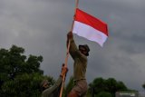 Prajurit Yon Taifib 2 Marinir TNI AL mengibarkan bendera merah putih setengah tiang di posko mereka di Pelabuhan Tanjung Wangi, Banyuwangi, Jawa Timur, Senin (26/4/2021). TNI AL mengibarkan bendera setengah tiang untuk menghormati 53 awak kapal selam KRI Nanggala-402 yang gugur di perairan Bali dan bendera setengah tiang tersebut akan dikibarkan selama 7 hari. Antara Jatim/Zabur Karuru