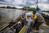 Petugas kepolisian membawa kotak suara saat mendsitribusikan logistik pemungutan suara ulang (PSU) ke TPS di Pulau Bromo, Banjarmasin, Kalimantan Selatan, Selasa (27/4/2021). Komisi Pemilihan Umum (KPU) Kota Banjarmasin mulai mendistribusikan logistik untuk pelaksanaan pemungutan suara ulang Pilkada Kota Banjarmasin tahun 2020 di tiga kelurahan di Kecamatan Banjarmasin Selatan pada 28 April 2021. Foto Antaranews Kalsel/Bayu Pratama S.