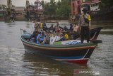 Petugas gabungan membawa kotak suara menggunakan perahu bermesin saat mendsitribusikan logistik pemungutan suara ulang (PSU) ke TPS di Desa Pulau Bromo, Banjarmasin, Kalimantan Selatan, Selasa (27/4/2021). Komisi Pemilihan Umum (KPU) Kota Banjarmasin mulai mendistribusikan logistik untuk pelaksanaan pemungutan suara ulang Pilkada Kota Banjarmasin tahun 2020 di tiga kelurahan di Kecamatan Banjarmasin Selatan pada 28 April 2021. Foto Antaranews Kalsel/Bayu Pratama S.