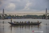 Petugas gabungan membawa kotak suara menggunakan perahu bermesin saat mendsitribusikan logistik pemungutan suara ulang (PSU) ke TPS di Desa Pulau Bromo, Banjarmasin, Kalimantan Selatan, Selasa (27/4/2021). Komisi Pemilihan Umum (KPU) Kota Banjarmasin mulai mendistribusikan logistik untuk pelaksanaan pemungutan suara ulang Pilkada Kota Banjarmasin tahun 2020 di tiga kelurahan di Kecamatan Banjarmasin Selatan pada 28 April 2021. Foto Antaranews Kalsel/Bayu Pratama S.