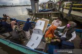 Petugas gabungan membawa membawa bilik suara saat mendsitribusikan logistik pemungutan suara ulang (PSU) ke TPS di Pulau Bromo, Banjarmasin, Kalimantan Selatan, Selasa (27/4/2021). Komisi Pemilihan Umum (KPU) Kota Banjarmasin mulai mendistribusikan logistik untuk pelaksanaan pemungutan suara ulang Pilkada Kota Banjarmasin tahun 2020 di tiga kelurahan di Kecamatan Banjarmasin Selatan pada 28 April 2021. Foto Antaranews Kalsel/Bayu Pratama S.