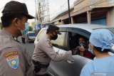  Polisi memeriksa identitas seorang pengemudi saat penyekatan larangan mudik di Kota Madiun, Jawa Timur, Jumat (30/4/2021). Penyekatan yang dilakukan petugas gabungan TNI, Polri, Satpol PP, Badan Penanggulanan Bencana Daerah (BPBD) dan Dinas Kesehatan dimaksudkan untuk mengantisipasi pemudik masuk wilayah Kota Madiun guna pencegahan penularan COVID-19. Antara Jatim/Siswowidodo/zk