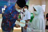 PENYERAHAN BEASISWA PADA PERINGATAN MAY DAY. Gubernur Aceh, Nova Iriansyah menyerahkan buku tabungan beasiswa kepada pelajar secara simbolis saat memperingati May Day di Kantor BPJS Ketenagakerjaan, Banda Aceh, Aceh, Sabtu (1/5/2021). Peringatan Hari Buruh di Aceh itu, diisi dengan kegiatan penyerahan biasiswa kepada sebanyak 226 pelajar, anak ahli waris peserta BPJS untuk biaya pendidikan mulai dari TK hingga Perguruan Tinggi dn selain bantuan  sembako oleh pemerintah Aceh. ANTARA FOTO/Ampelsa.