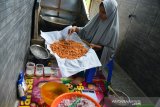 PERMINTAAN BAWANG GORENG HOME INDUSTRI. Pekerja menggoreng bawang saat proses produksi menjadi produk bawang goreng  di salah satu home industri, Desa Lampeunerut, kecamatan Darul Imara, Kabupaten Aceh Besar, Aceh, Sabtu (1/5/2021). Pelaku usaha menyatakan produksi bawang goreng tidak terdampak pandemi COVID-19 dan menjelang hari raya Idul Fitri permintaan produk bawang goreng meningkat kisaran 75 persen  dengan harga penjualan Rp40.000 hingga Rp58.000 per bungkus menurut ukurannya. ANTARA FOTO/Ampelsa.