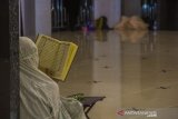 Umat Islam membaca Al Quran ketika beritikaf di Masjid Hasanuddin Madjedi, Banjarmasin, Kalimantan Selatan, Senin (3/5/2021). Itikaf di 10 hari terakhir Bulan Ramadan bertujuan meraih malam kemuliaan, dengan membaca Al-Quran, salat Tahajud, dan berzikir. Foto Antaranews Kalsel/Bayu Pratama S.