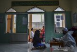 Warga menunaikan pembayaran zakat fitrah di Masjid Al Wasilah, Kampung Cinta Rasa, Kota Tasikmalaya, Jawa Barat, Selasa (4/5/2021). Panitia pengumpulan zakat fitrah di masjid tersebut menerima pembayaran zakat fitrah oleh warga sambil menggunakan Alat Pelindung Diri (APD) COVID-19 untuk mensosialisasikan tentang pentingnya protokol kesehatan. ANTARA JABAR/Adeng Bustomi/agr