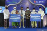 Group Head XL Axiata Region East, Dodik Ariyanto (ke tiga kiri) Staf Khusus Kemenkopolhukam, Rizal Mustary (ke empat kiri) dan Imam Marsudi (kanan) menyerahkan donasi laptop kepada perwakilan pondok pesantren di Pesantren As-Sayuti, Pamekasan,  Jawa Timur, Selasa (4/5/2021). XL Axiata memberikan 100 unit laptop  kepada 12 pondok pesantren di sejumlah daerah,  empat di antaranya berada di Jawa Timur. Donasi ini merupakan bagian dari program Desa Digital yang diinisiasi XL Axiata. Menkopolhukam Mahfud MD bersama Presiden Direktur & CEO XL Axiata Dian Siswarini menyaksikan secara daring  penyerahan donasi tersebut.  Antara Jatim/Saiful Bahri/zk