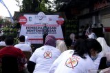 Pedagang pasar mengikuti acara peluncuran program Stop Rentenir Pasar di Rogojampi,  Banyuwangi, Jawa Timur, Rabu (5/5/2021). Otoritas Jasa Keuangan (OJK) meluncurkan program Stop Rentenir Pasar yang bertujuan untuk mengalihkan akses keuangan pedagang yang kerap meminjam pada rentenir dengan bunga tinggi, menuju ke perbankan resmi dengan bunga lebih rendah. Antara Jatim/Budi Candra Setya/zk