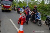 Petugas gabungan menaruh pembatas jalan saat mengatur arus lalu lintas kendaraan dari arah Bekasi menuju Karawang pada hari pertama penyekatan larangan mudik di perbatasan Karawang-Bekasi, Jawa Barat, Kamis (6/5/2020). Penyekatan akses transportasi di sejumlah perbatasan kota tersebut dilakukan saat penerapan larangan mudik Lebaran pada 6 -17 Mei 2021 sebagai upaya pencegahan kasus penularan COVID-19. ANTARA JABAR/M Ibnu Chazar/agr