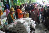 Guru memberikan beras kemasan kepada anak yatim saat penyaluran zakat fitrah di SDN Lawangan Daya 2, Pamekasan,  Jawa Timur, Kamis (6/5/2021). Sekitar 400 paket  beras kemasan dan zakat mal dari siswa sekolah itu, disalurkan kepada anak yatim dan warga tidak mampu di lingkungan sekolah tersebut. Antara Jatim/Saiful Bahri/zk