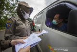 Petugas gabungan memeriksa dokumen pengendara yang melintas di Pos Penyekatan, Binuang, Kabupaten Tapin, Kalimantan Selatan, Kamis (6/5/2021). Pemerintah Provinsi Kalimantan Selatan melakukan pemberlakuan kebijakan peniadaan mudik hari raya Idul Fitri 1442 Hijriah lintas Kota/Kabupaten/Provinsi sebagai upaya pengendalian penyebaran COVID-19 di Kalimantan Selatan.Foto Antaranews Kalsel/Bayu Pratama S.