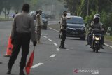 Petugas gabungan menghentikan kendaraan untuk pemeriksaan dokumen perjalanan di jalur Pantura Susukan, Kabupaten Cirebon, Jawa Barat, Kamis (6/5/2021). Penyekatan yang dilakukan petugas gabungan TNI, Polri, Satpol PP dan Dishub serta dinas kesehatan itu dilakukan sebagai upaya larangan mudik di perbatasan Indramayu dan Cirebon. ANTARA JABAR/Dedhez Anggara/agr