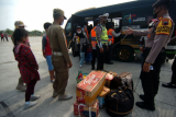 Personel kepolisian terpaksa menurunkan penumpang travel gelap saat terjaring penyekatan pemudik di pintu keluar tol Pejagan-Pemalang, Adiwerna, Kabupaten Tegal, Jawa Tengah, Kamis (6/5/2021). Polres Tegal melakukan tes usap antigen dan menurunkan puluhan penumpang travel gelap akibat kendaraannya ditahan saat ingin mudik ke Pemalang. ANTARA FOTO/Oky Lukmansyah/hp.