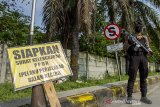 Petugas kepolisian bersenjata lengkap berjaga di jalur Gerbang Tol Karawang Barat saat penyekatan larangan mudik di Karawang, Jawa Barat, Jumat (7/5/2021). Pengetatan penjagaan dalam penyekatan akses transportasi menuju gerbang tol tersebut sebagai upaya antisipasi kendaraan yang nekat mudik menerobos jalur penyekatan. ANTARA JABAR/M Ibnu Chazar/agr