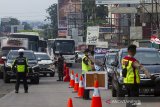 Petugas gabungan mengatur kendaraan yang melintas untuk diperiksa di check point penyekatan arus mudik di Gerbang Tol Karawang Barat, Jawa Barat, Jumat (7/5/2021). Pemeriksaan pengendara di akses transportasi tersebut dalam rangka pemberlakuan larangan mudik Lebaran dan mengantisipasi risiko peningkatan kasus penularan COVID-19 jelang perayaan Hari Raya Idul Fitri 1442 H. ANTARA JABAR/M Ibnu Chazar/agr