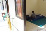 Seorang Pekerja Migran Indonesia (PMI) berada di dalam kamar saat menjalani karantina di Shelter Isolasi Kolektif Penanganan COVID-19 di Jiwan, Kabupaten Madiun, Jawa Timur, Sabtu (8/5/2021). Di shelter isolasi tersebut saat ini terdapat tujuh orang PMI terdiri enam perempuan dan seorang laki-laki yang pulang marantau dari luar negeri antara lain Malaysia, Hongkong dan Dubai (Uni Emirat Arab) menjalani karantina sebelum pulang ke kampung halaman masing-masing guna penanggulangan COVID-19. Antara Jatim/Siswowidodo/zk